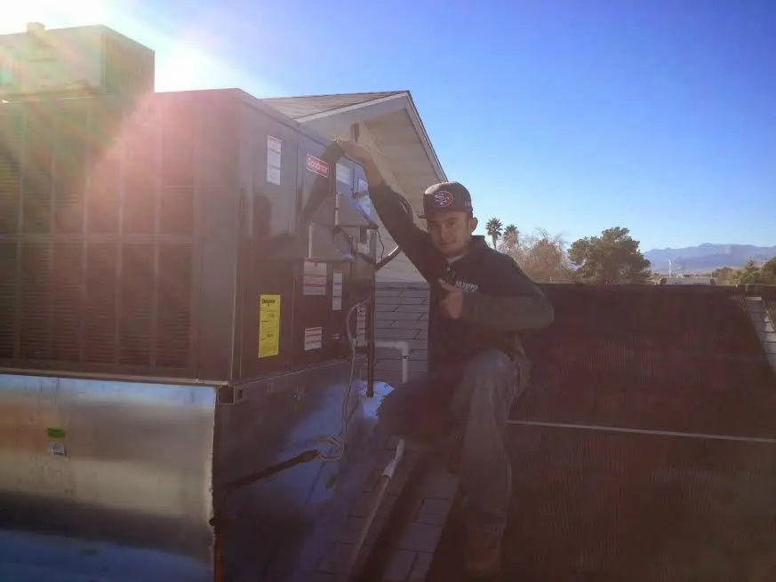 HVAC technician performing AC Tune-Up on a rooftop unit in Salinas
